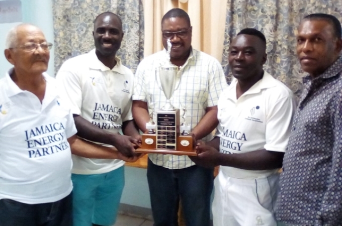 Jamaica Cricket Association chief executive officer Courtney Francis (centre) presents the champions trophy to Innswood Old Boys skipper Kirk Gordon (2nd right) and Basement caption Akbar Moodie (2nd left). Sharing in the presentation are Jamaica Cricket Association president Wilford ‘Billy’ Heaven (right) and St Catherine Cricket Association life member David Miranda.