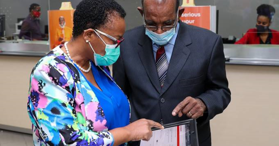 Seniors like Mr. Percival Latouche ( right), President of the Jamaica Association for Resettlement of Returning Residents are being encouraged to use Scotiabank’s digital channels. Here Latouche is assisted by Pamela Douglas, manager of the Scotiabank New Kingston branch to use the new Scotiabank mobile app.