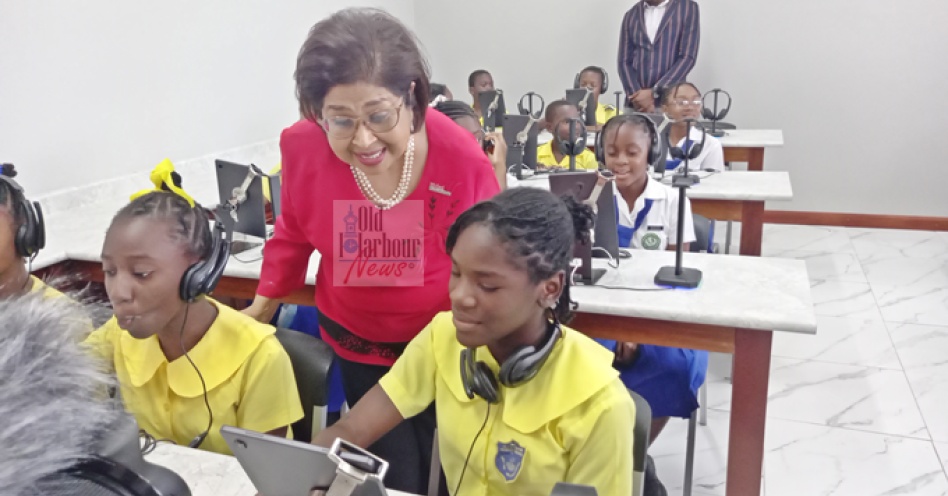 Jean Lowrie-Chin, chair, Digicel Foundation observes a student inside the ICT classroom. (OH News Photo)