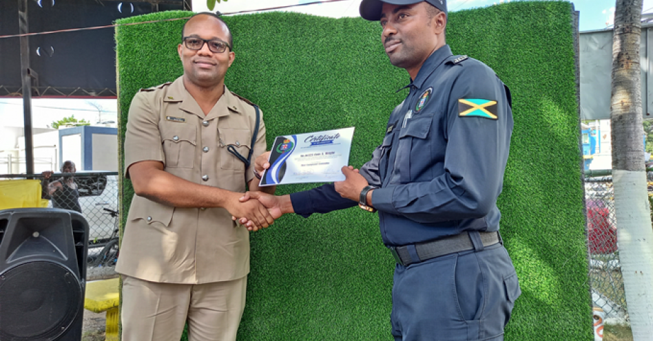 Insp. Randy Grant (left) presents Cst. Alwayne Wright of the traffic unit with his certificate of recognition. (OH News Photo)