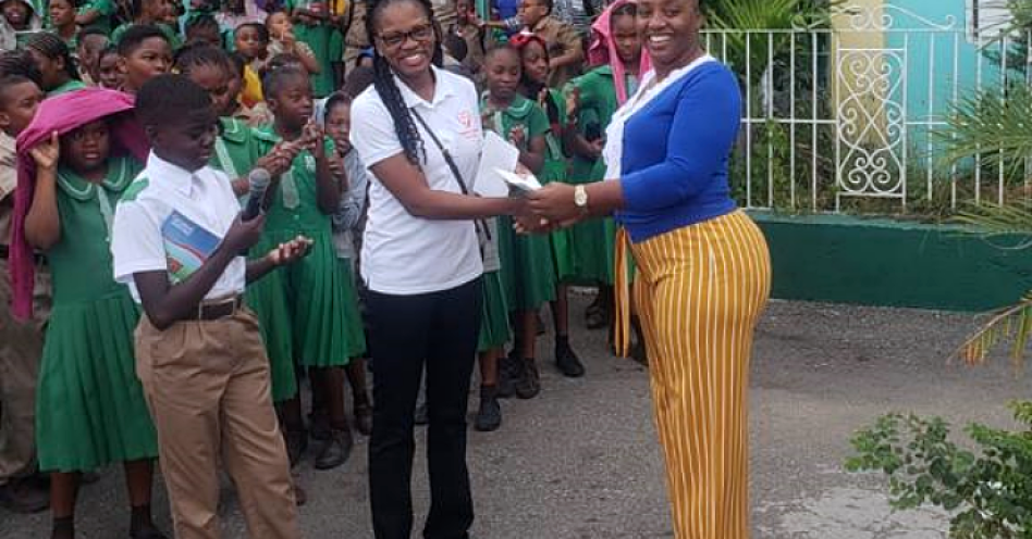 Dr Odette Thomas (left) presents Sophia Thompson-Hamilton with her cash prize.