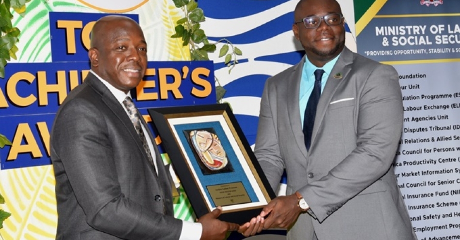 Minister of Labour and Social Security, Hon. Pearnel Charles Jr., (left), presents Jordon Freeman with the 2024 Programme of Advancement through Health and Education (PATH) Trailblazer Award, during the PATH Top Achiever’s Awards Ceremony at the Spanish Court Hotel in New Kingston on April 11.(JIS Photo)