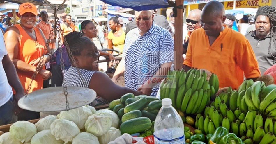 People’s National Party (PNP) president Dr Peter Phillips (left) meets a vendor in the Old Harbour Market during a tour of the town on October 12, 2019. Among the touring party is Dr Kurt Waul (right) is PNP candidate for St Catherine South West. (OH News Photo)