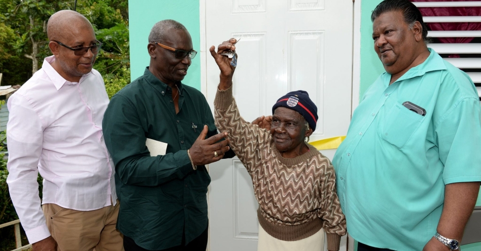Ninety-five year old Nora Johnson (second right), proudly displays the key to her new home which was handed over to her by Local Government and Community Development Minister, Hon. Desmond McKenzie (second left), during a ceremony in Mendez District, Point Hill, St. Catherine on Monday (October 7). Looking on (from left) are Mayor of Spanish Town, Councillor Norman Scott; and Councillor for the Point Hill Division, Wesley Suckoo. Ms. Johnson was provided with the studio unit under the Government’s Indigent Housing Programme. (JIS Photo)