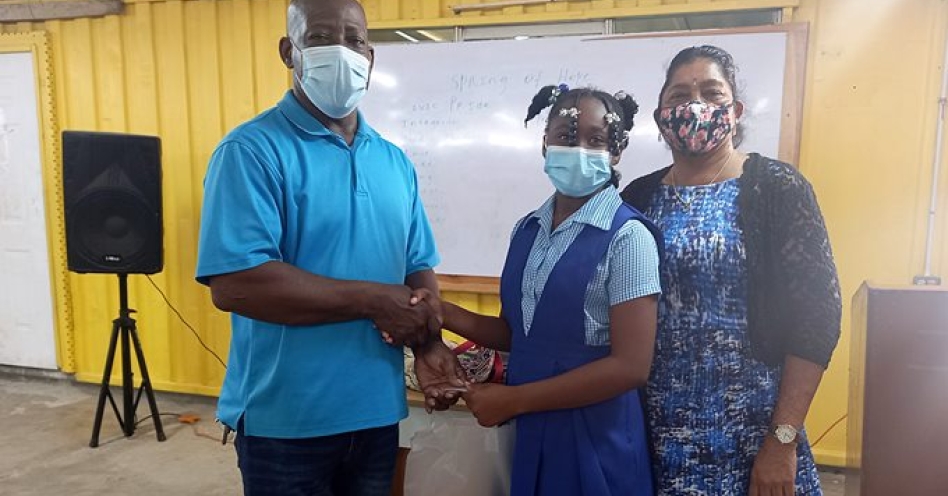 Michael Harris of the Harris Family Vision Foundation Inc makes a presentation to a student during the Spring of Hope programme while Audrey Maragh-Fuller (right) and Patrick Binns share in the moment. (OH News Photo)