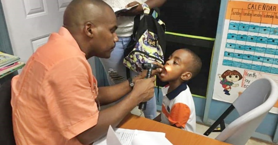 Dr Kurt Waul (left) conducts a medical examination of a child in the constituency