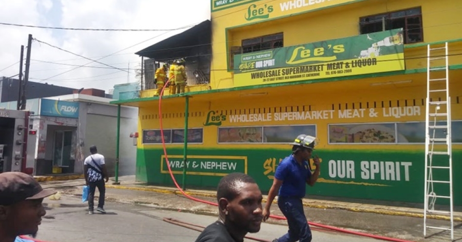 Firefighters at Lee's Wholesale Supermarket in Old Harbour. (OH News Photo)