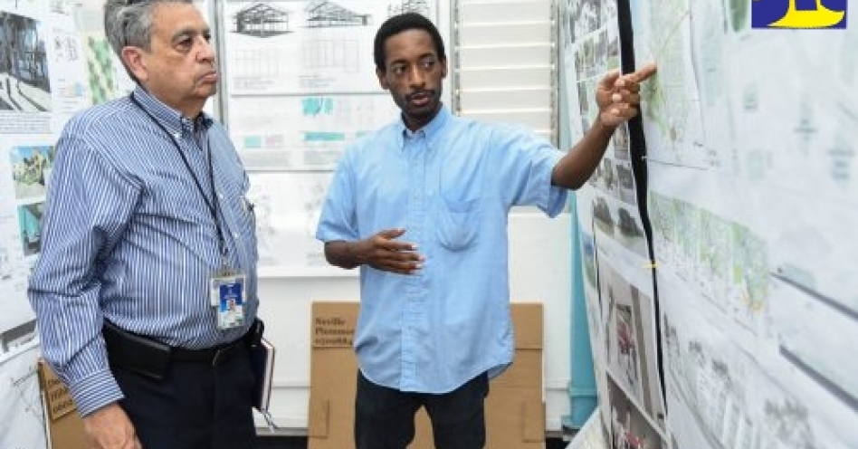 Senior Advisor and Consultant to Minister without Portfolio in the Office of the Prime Minister, Hon. Mike Henry, Bindley Sangster (left), listens with interest as Neville Plummer, Master of Architecture student at the University of Technology (UTech) Caribbean School of Architecture (CSA), explains the concept behind his final-year project. Occasion was a visit by the Core Implementation Team of the Vernamfield Development project to the school during its 30th anniversary exhibition. (JIS Photo)